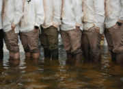 Groomsmen and guests stand knee deep in floodwaters wearing the traditional barong tagalog at Barasoain church in Malolos, Bulacan province, Philippines on Tuesday, July 22, 2025. Aaron Favila/AP