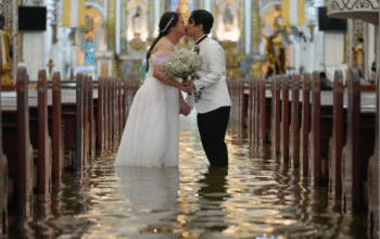 Newlyweds Jade Rick Verdillo right, and Jamaica kiss during their wedding at the flooded Barasoain church in Malolos, Bulacan province, Philippines on Tuesday, July 22, 2025. Aaron Favila/AP