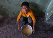 Labarik palestinianu ida ne'ebé dezlokadu tuur iha bikan ida ho sopa lentil nian ne'ebé nia simu iha pontu distribuisaun ai-han nian iha Sidade Gaza iha norte Faixa Gaza nian iha loron 25 fulan-Jullu tinan 2025.Omar Al-qattaa/AFP via Getty Images
