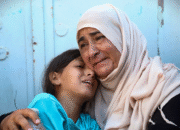 Feto ida ho labarik ida reajen hafoin identifika mate-isin hosi membru família ida iha ospitál Nasser, entre palestinianu sira ne'ebé mate iha atake israelita sira iha kampu refujiadu al-Mawasi no bairru leste sira Khan Yunis nian iha súl Faixa Gaza nian, iha loron 24 fulan-Jullu tinan 2025.AFP liuhosi Getty Images