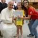 Pope Leo XIV bends down to take a photo with a girl taking part in the Vatican summer camp (@Vatican Media)